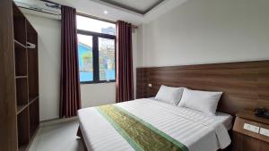 a bedroom with a large bed and a window at Thanh Hang Hotel near Emerald My Dinh in Hanoi