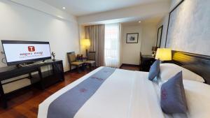 um quarto de hotel com uma cama e uma televisão de ecrã plano em Tara Angkor Hotel em Siem Reap