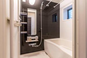 ein Badezimmer mit einer Badewanne, einem Waschbecken und einem WC in der Unterkunft T-BASE - Vacation STAY 21952v in Tokio