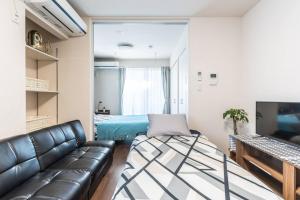 ein Wohnzimmer mit einem Sofa und einem Bett in der Unterkunft T-BASE - Vacation STAY 21952v in Tokio