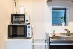 a kitchen with a microwave and a sink at T-BASE - Vacation STAY 21950v in Tokyo