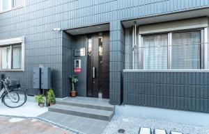 a house with a black door and a bike parked outside at T-BASE - Vacation STAY 21950v in Tokyo