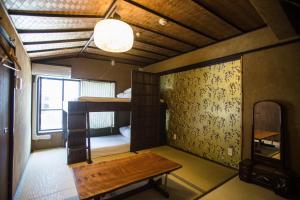 a room with a bunk bed and a table in it at Osaka Guest House U-En in Osaka