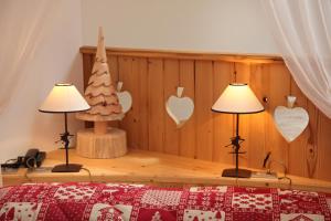 una camera da letto con due lampade e un albero di Natale sul muro di Hotel El Pilon a Pozza di Fassa