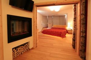 a bedroom with a bed and a fire place at Hotel El Pilon in Pozza di Fassa