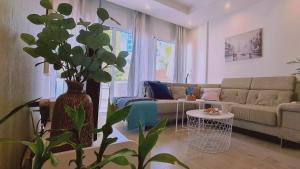 ein Wohnzimmer mit einem Sofa und einer Pflanze in der Unterkunft STAY Downtown Retreat in Limassol