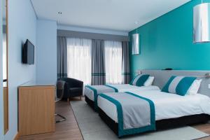 2 camas en una habitación de hotel con paredes azules en Alojamento do Zezere, en Ferreira do Zêzere
