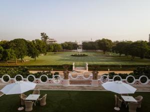 a view of a park with tables and umbrellas at Rajmahal Palace RAAS in Jaipur