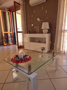 une table en verre au milieu d'un salon dans l'établissement NickyHouse Holiday Home, à Giffoni Sei Casali