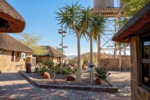a courtyard with two palm trees in a building at Mountain View Villa in Duwisib