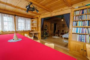 a dining room with a red table and a christmas tree at Dom Zako in Zakopane