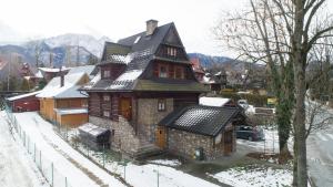 a large house with snow on the ground at Dom Zako in Zakopane