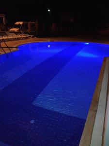 a large blue swimming pool lit up at night at Blue Sea Hotel & Spa in Kuşadası +15 photos