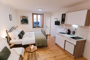 a kitchen and living room with a bed and a couch at Guest House Rosemary in Piran
