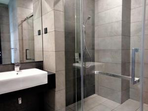 een badkamer met een wastafel en een glazen douche bij OPUS RESIDENCE KL I HomeBrickz in Kuala Lumpur +74 foto's