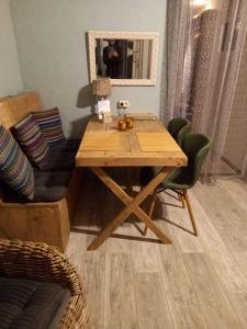 una mesa de madera en una sala de estar con espejo en Gastenverblijf 't Achterhoes, en Bellingwolde 17 fotos más