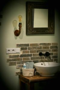 een badkamer met een wastafel en een spiegel aan een muur bij B&B Wood, Food & More in Alphen
