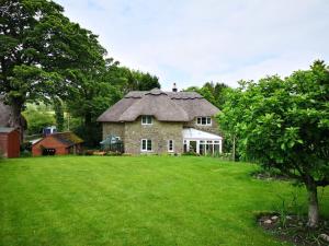 a large stone house with a grass yard at Kings Cottage - Heart of the Deverills in Warminster