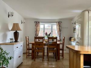 uma cozinha com uma mesa de jantar e cadeiras em Kings Cottage - Heart of the Deverills em Warminster