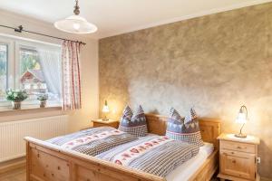 a bedroom with a bed with two lamps and a window at Ferienwohnung Waldruhe in Garmisch-Partenkirchen
