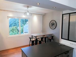 d'une salle à manger avec une table, des chaises et une fenêtre. dans l'établissement Chalet les Marmottons, à Cauterets