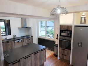 a kitchen with wooden cabinets and a black counter top at Chalet les Marmottons in Cauterets