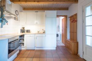 a kitchen with white appliances and a tile floor at Lütt Huus an de Geestkant in Langenhorn