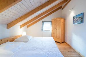 een slaapkamer met een groot wit bed en een raam bij Lütt Huus an de Geestkant in Langenhorn