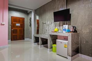 a room with a counter and a tv on a wall at The Guest Hotel Krabi in Krabi