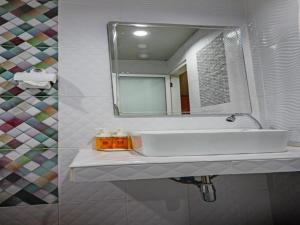 a bathroom with a white sink and a mirror at The Guest Hotel Krabi in Krabi town