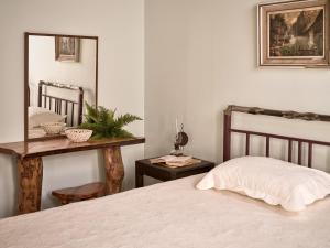 um quarto com uma cama e uma mesa com um espelho em Vafias Villa em Lithakia