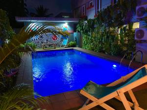 a swimming pool at night with a chair next to it at Angel Hotel in Lagos