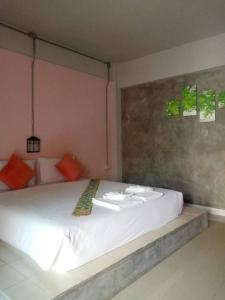 a bedroom with a large white bed in a room at The Guest Hotel Krabi in Krabi