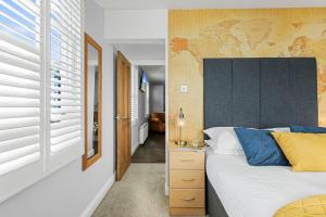 a bedroom with a bed with a large headboard at Southbank TOWN HOUSE in Torquay