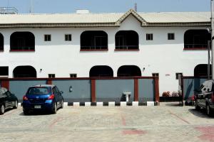 ラゴスにあるMariners Suites Lagosの駐車場付白い建物