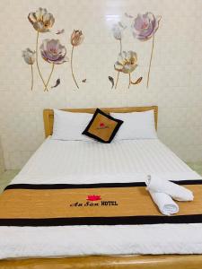 um quarto com uma cama com flores na parede em An San Hotel em Dĩ An