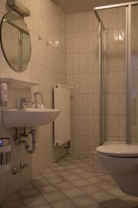 uma casa de banho com um lavatório, um WC e um espelho. em Hotel Ristorante Milano em Bad Tölz