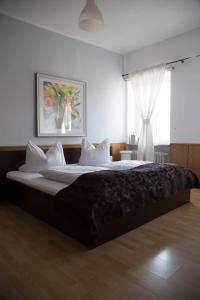a bedroom with a large bed with white sheets and a window at Hotel Ristorante Milano in Bad Tölz