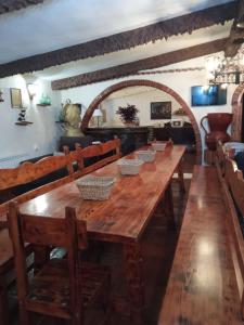 Una mesa larga de madera con cuencos encima. en CASA TURÍSTICA Villa Carmen, CON AMPLIO JARDIN QUE INCLUYE BARBACOA, 2 PORCHES, PARKING PRIVADO Y PISCINA, en Arenzana de Abajo