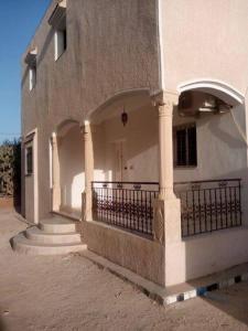 a white building with a balcony and a door at Diar Karim Djerba in Midoun