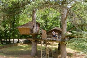 a tree house in a park with people in it at Parc de la Belle in Magne	