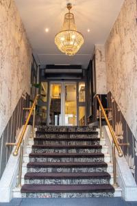 a set of stairs in a lobby with a chandelier at The Lancaster Hotel Amsterdam in Amsterdam