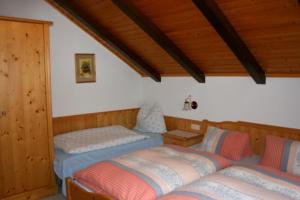 two beds in a room with wooden ceilings at Apartment Bleisch in Gosau