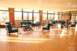 Jewel Luxor Hotel في الأقصر: غرفة انتظار مع كراسي وطاولات ونوافذ