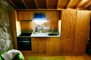 a small kitchen with a sink and a stove at Casa do Castanheiro - Eido do Pomar in Arcos de Valdevez +7 photos
