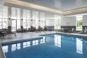 una piscina en el vestíbulo del hotel con sillas y mesas en Hyatt Place Evansville, en Evansville