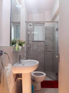 a bathroom with a toilet and a sink and a shower at Nyumba Nzuri 2 bedroom apartment central of NBO in Nairobi