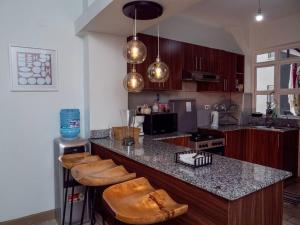 a kitchen with a counter and some wooden cabinets at Nyumba Nzuri 2 bedroom apartment central of NBO in Nairobi