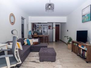 a living room with a couch and a tv at Nyumba Nzuri 2 bedroom apartment central of NBO in Nairobi