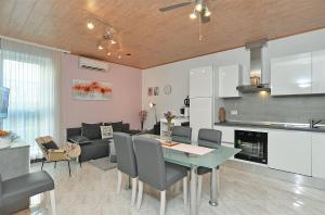 kuchnia i salon ze stołem i krzesłami w obiekcie Apartments Jasna 1128 w Fažanie